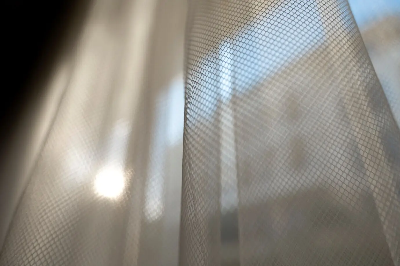 Nahaufnahme von Vorhängen und Sonnenschein.